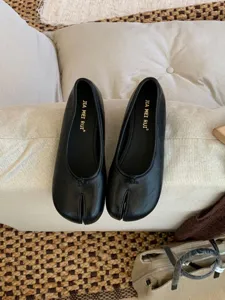 Vista detallada de zapatos planos Mary Jane negros con punta dividida, estilo retro.