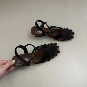 Black strap sandal detail showing brown suede insole and comfortable low block heel.