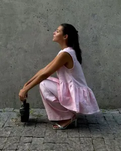Pink sleeveless top and trousers set worn by model in outdoor scene detail view