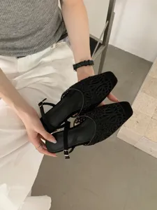 Black hollow square-toe women shoe detail, stylish retro shallow single shoe design.