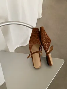 Detail view of brown suede cutout pointed toe women sandals, elegant retro shoe texture.