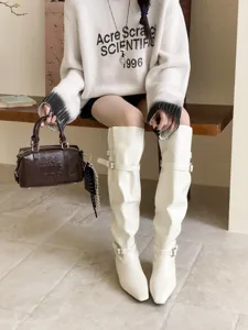 Details of chic white square-toe flat knee-high boots with stylish side buckle straps.
