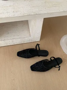 Detailed view of black cutout square toe slingback flat shoes with elegant embroidery.