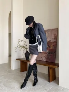 Detailed view of fashionable autumn winter knee-high boots outfit in minimalist interior scene