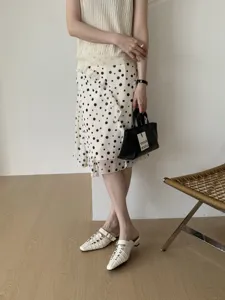 Dettaglio di comodi sabot bianchi intrecciati con tacco basso, eleganti sandali estivi casual.