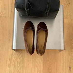 Detail view of brown velvet ballet flats with dainty bow, showcasing soft texture and sweet style.