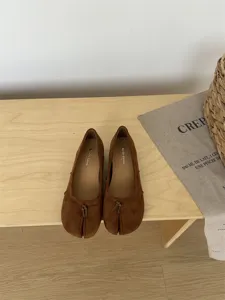 Vue détaillée de chaussures plates tabi en daim marron ballerines avec joli nœud élégant.