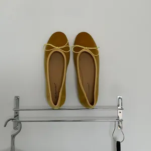 Velvet ballet flats detail view, featuring yellow bow ties and comfortable flat sole design.