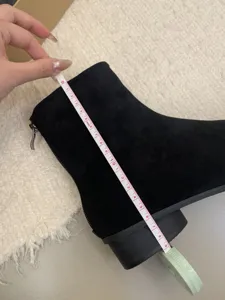 Vue détaillée montrant la mesure précise de la hauteur de tige de la bottine noire suédée.