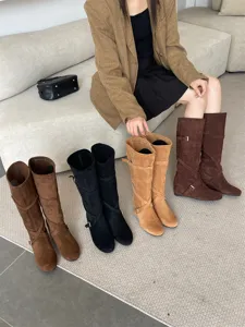 Detalles de las elegantes botas altas para mujer con cuña y acabado de ante suave.