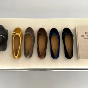 Detailed top-down view of colorful velvet ballet flats arranged neatly on a ribbed bench.