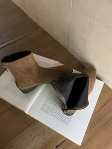 Vue détaillée de bottines élégantes en suède marron avec talon bloc et fermeture éclair.