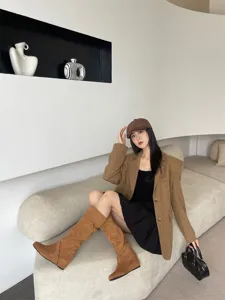 Vista detallada de botas altas de ante marron con tacon interno integrado para el invierno.