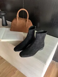 Vue détaillée de ces bottines à talons carrés en suédine noire au design élégant.