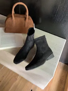 Detail de bottines noires en suade avec bout carre et design retro elegant et chic.