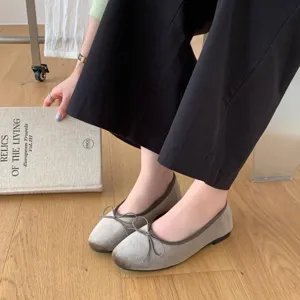 Detailed view of grey velvet ballet flats, comfortable low-heel slip-on shoes with cute bow design.