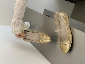 Detailed view of sparkly gold sequin Mary Jane flats, showcasing the cute bow and strap design.