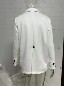 Vista detallada de la parte posterior de un blazer blanco de mujer con abertura y puños.