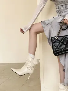 Botines cortos de punta con tacón de aguja en detalle, calzado elegante de color crema.
