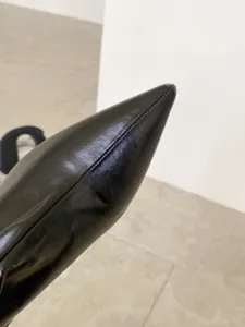 Primer plano detallado de la bota de cuero negro con punta fina y costuras delicadas.