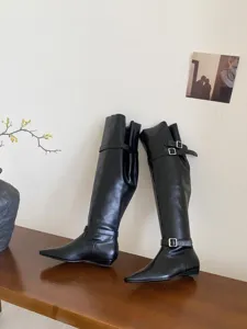 Detailed view of stylish black over-the-knee boots with sleek square toe and buckle.