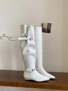 Detail view of elegant white over-the-knee boots featuring square toe and chic double buckles.