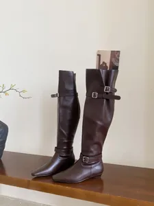 Elegant women's knee-high boots featuring a square toe, low flat heel, and chic metal buckle straps.