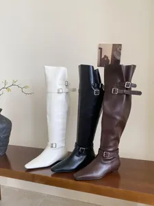 Stylish women over-the-knee long boots with square toe and flat low heel, chic buckle details.