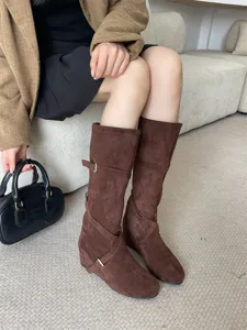 Botas de ante marrón a media pantorrilla con correas de hebilla y cuña oculta para otoño.
