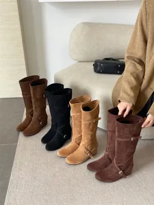 Vista detallada de botas altas de cuña de ante para mujer con tira de hebilla para otoño invierno.