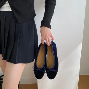 Close-up of navy velvet ballet flats with cute bow, showing soft inner sole and flat design.