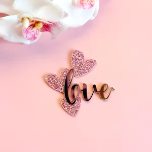Vue de detail de topper de gateau coeur amour en acrylique, finition pailletee romantique.
