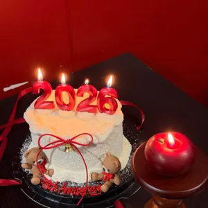 Detail shot of red 2026 number cake candles featuring cute teddy bears and elegant festive red bow.