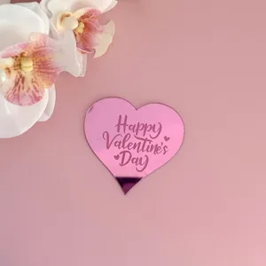 Gros plan détaillé d'un cake topper cœur rose avec texte élégant et décorations florales.