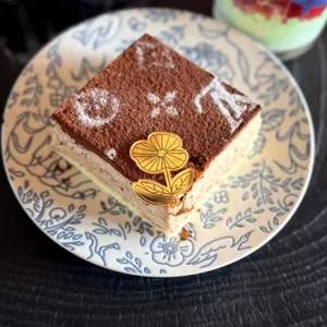 Torta al cioccolato quadrata con motivo monogramma e topper per torta in acrilico fiore dorato.
