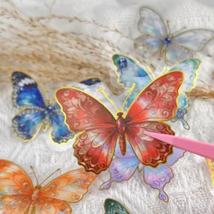 Detailed close-up shot of transparent PET butterfly stickers with exquisite gold foil and gem accents.