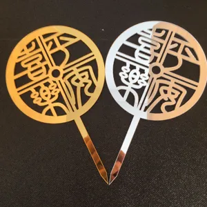 Close-up of gold and silver acrylic cake topper featuring traditional Chinese hollow blessing design.
