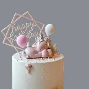 Primer plano detallado del lindo juego de decoración para pastel de cumpleaños de unicornio rosa.