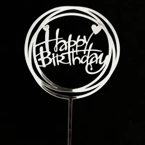 Vista de detalle de cake topper Happy Birthday de acrilico plateado, anillos y corazon.