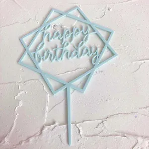 Detalle en primer plano del adorno de tarta de acrílico azul claro con diseño geométrico.