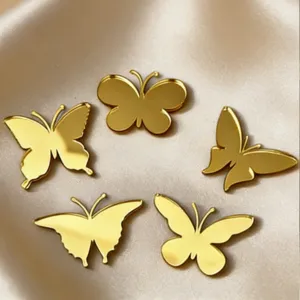 Close-up detail of golden acrylic butterfly cake toppers on smooth fabric background.