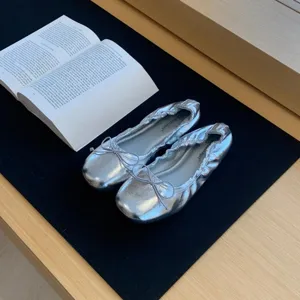 Gedetailleerd overzicht zilveren platte ballerina's met strik, stijlvolle damesschoenen.