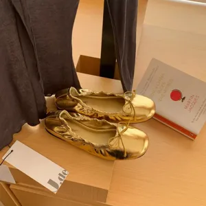 Metalen gouden ballerina's met schattige strik, klassieke ronde platte damesschoenen.