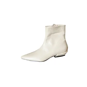 Détail de bottine à talon bas et bout pointu, design de chaussures de mode crème.