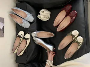 Close-up of multi-color flat ballet shoes with cute bow details and clear insoles.