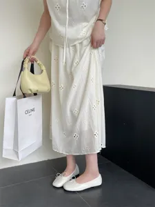 Detailed view of white flat ballet shoes for women, featuring a classic shallow cut and delicate bow.