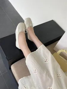 Close-up detail of cream white flat ballet shoes, elegant shallow mouth design with cute bow.