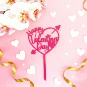 Vue rapprochee d un topper de gateau rose en acrylique avec ecriture Happy Valentines Day.