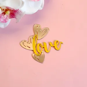 Vue détaillée d'un élégant cake topper love en acrylique doré pour la Saint-Valentin.