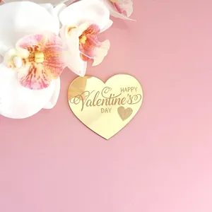 Gros plan d'un topper de gâteau cœur en acrylique miroir doré gravé Saint Valentin.